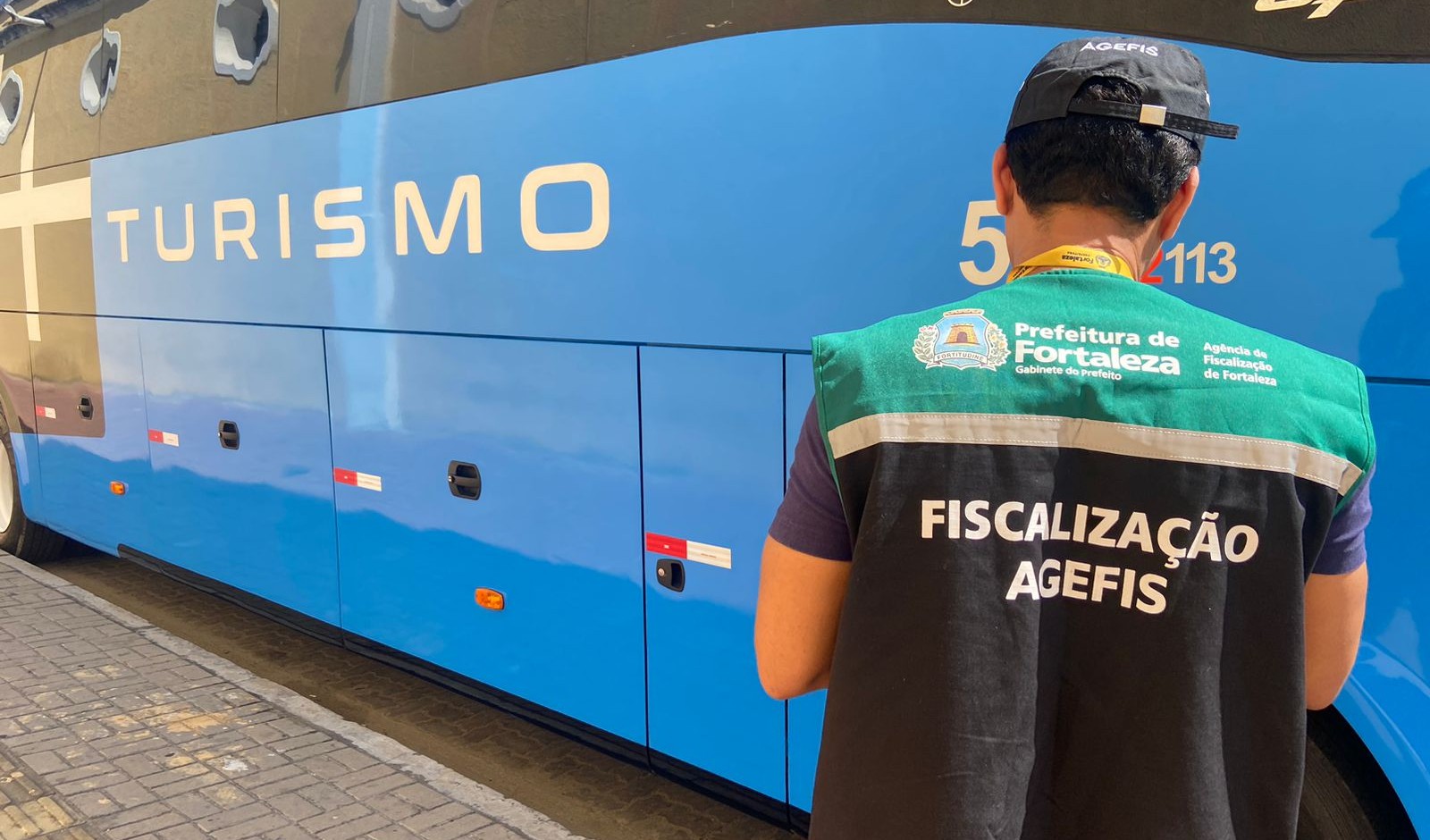 fiscal da agefis na frente de um ônibus